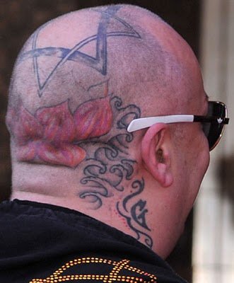  a cross on his right shoulder and some unknown text on his right hand